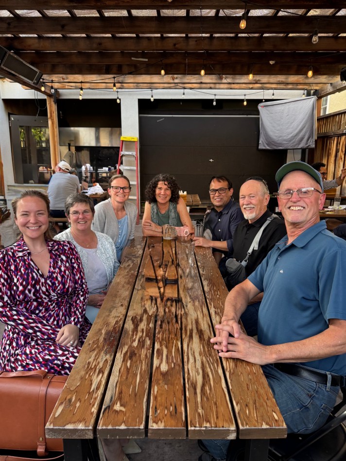 members of UI sitting at a wooden table